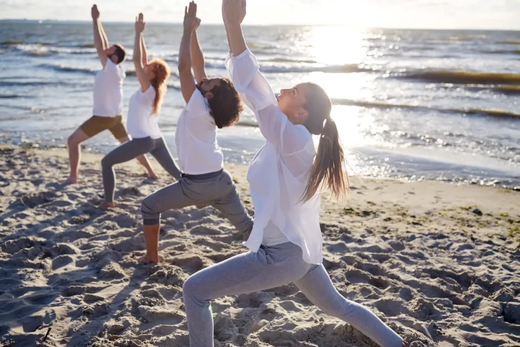 Séance de yoga sur la plage face à l’océan, expérience bien-être proposée par la conciergerie de La Plume du Cap au Cap-Ferret
